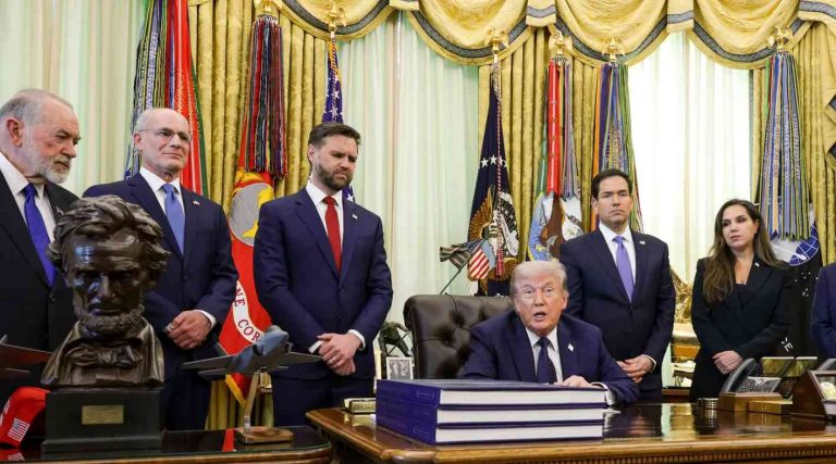 president Trump seated at Resolute Desk with JD Vance and cabinet officials standing