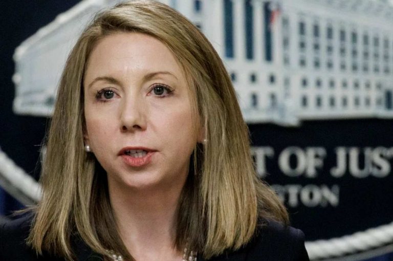 department of Justice official speaking at podium with DOJ seal visible in background
