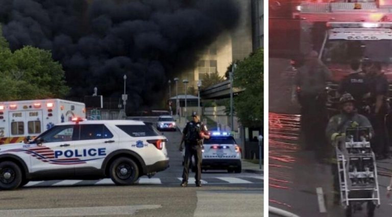 DC police SUV and ambulance block street as thick black smoke billows from building fire