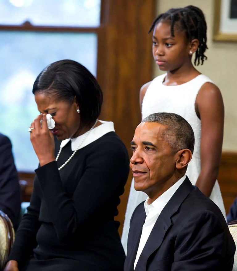 michelle Obama wipes tears with tissue while seated beside Barack Obama, with daughter