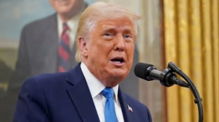 donald Trump speaking at podium with portrait of Ronald Reagan visible behind him in Oval