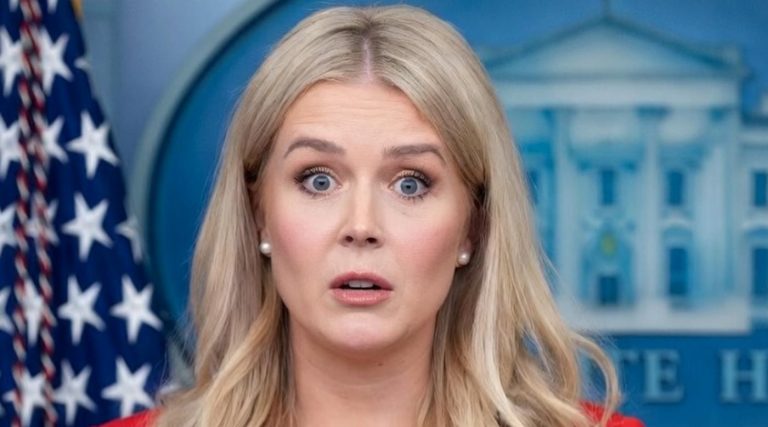 white House Press Secretary Karoline Leavitt speaking at podium with American flag and