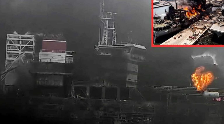 burning naval vessel marked 461 engulfed in flames at dockyard with thick black smoke