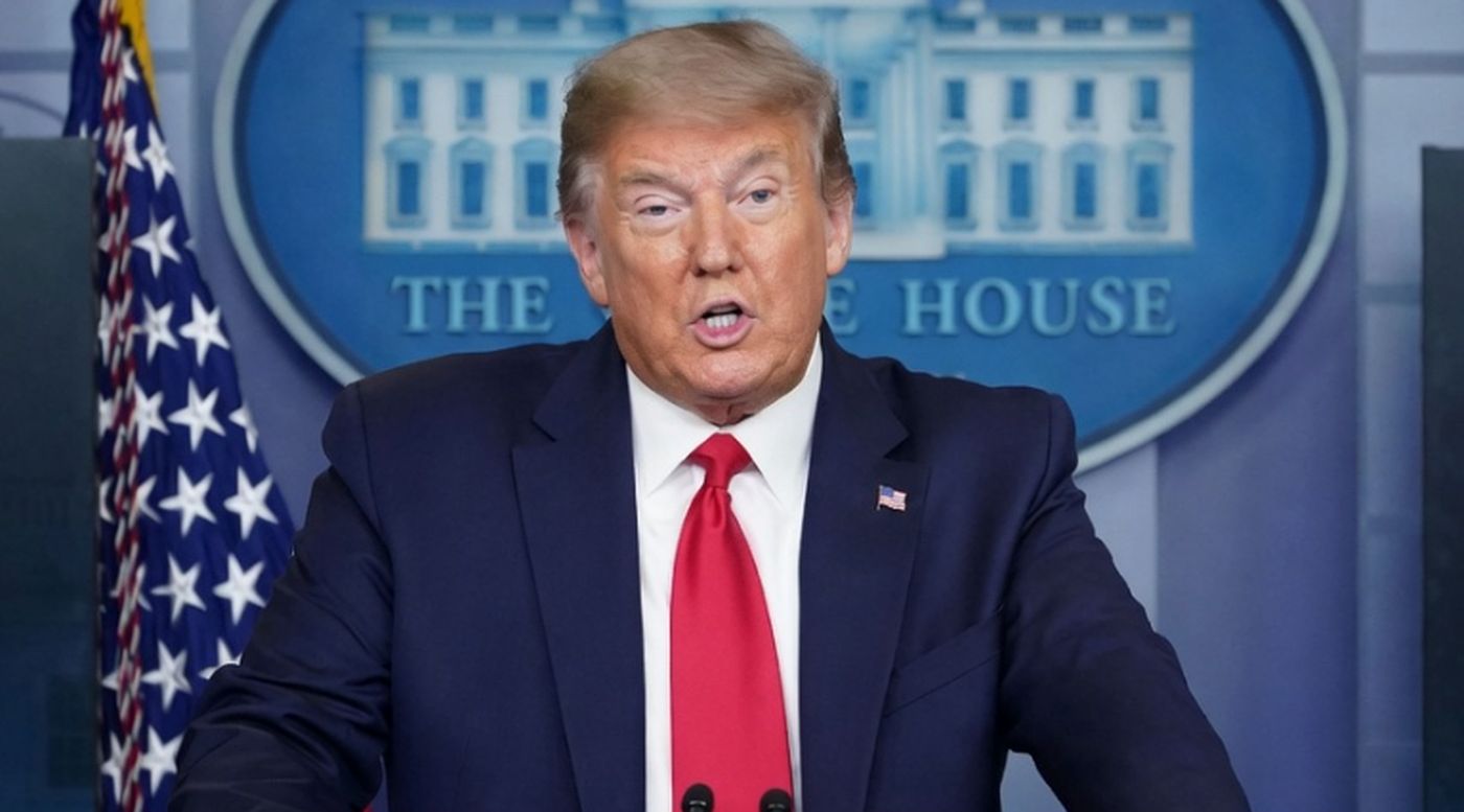 donald Trump speaking at White House podium with American flag and seal visible behind him