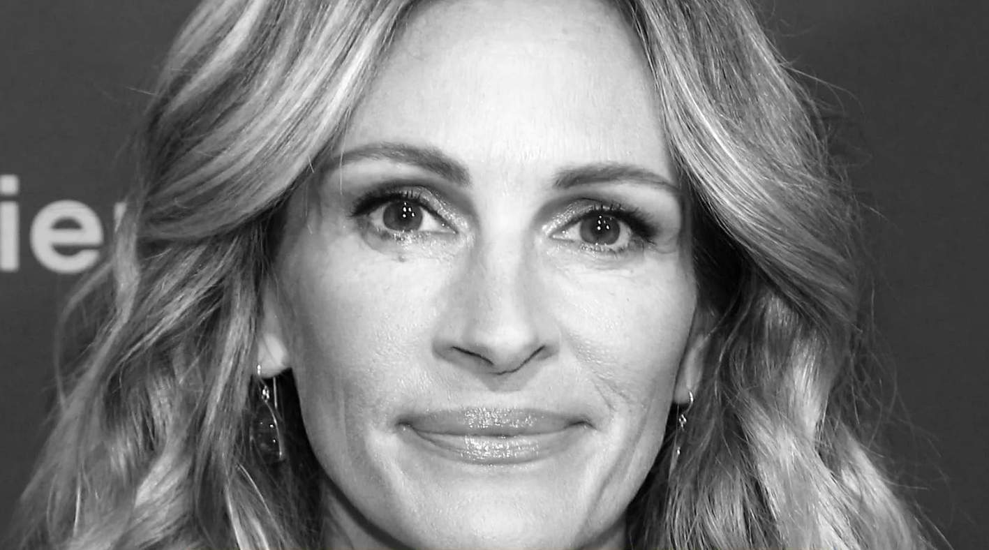 black-and-white close-up portrait of Julia Roberts with wavy blonde hair and dangling