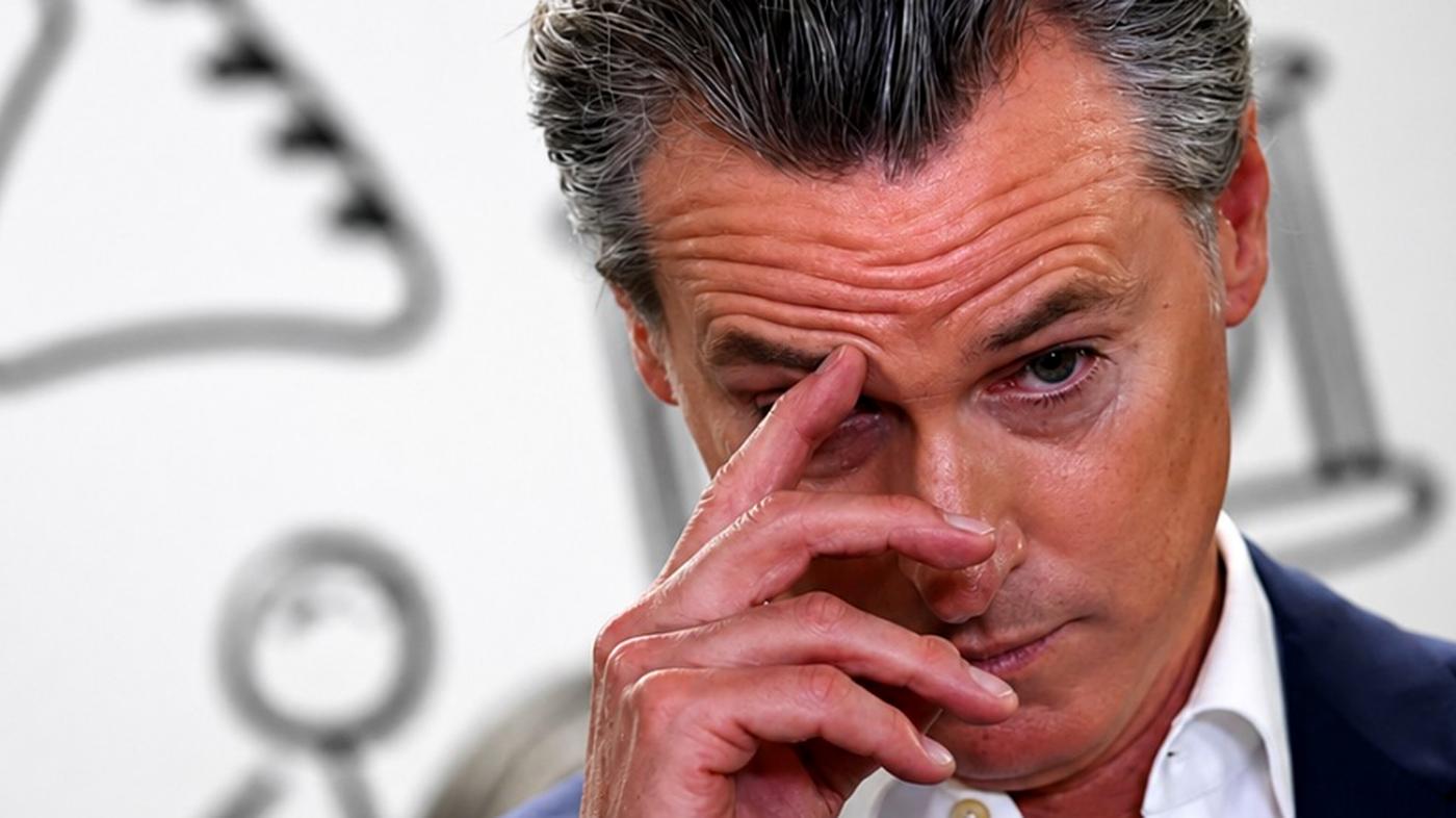 Gavin Newsom touching his forehead at an event.