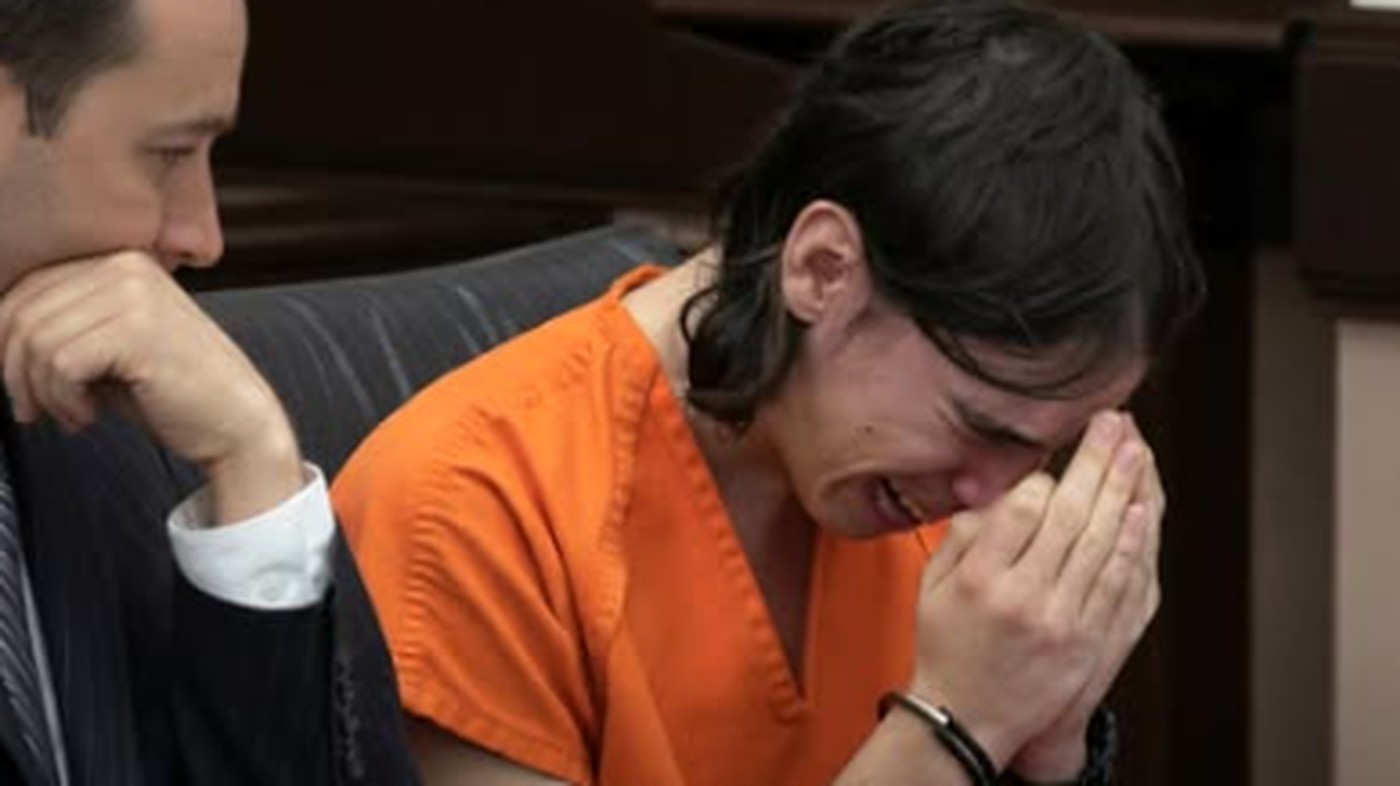 Teen crying in orange jumpsuit during court hearing