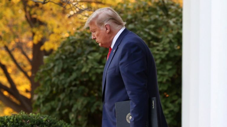 Trump walking with folder at White House