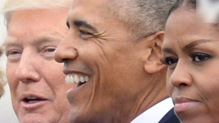 barack Obama smiling at a public event with Donald Trump and Michelle Obama