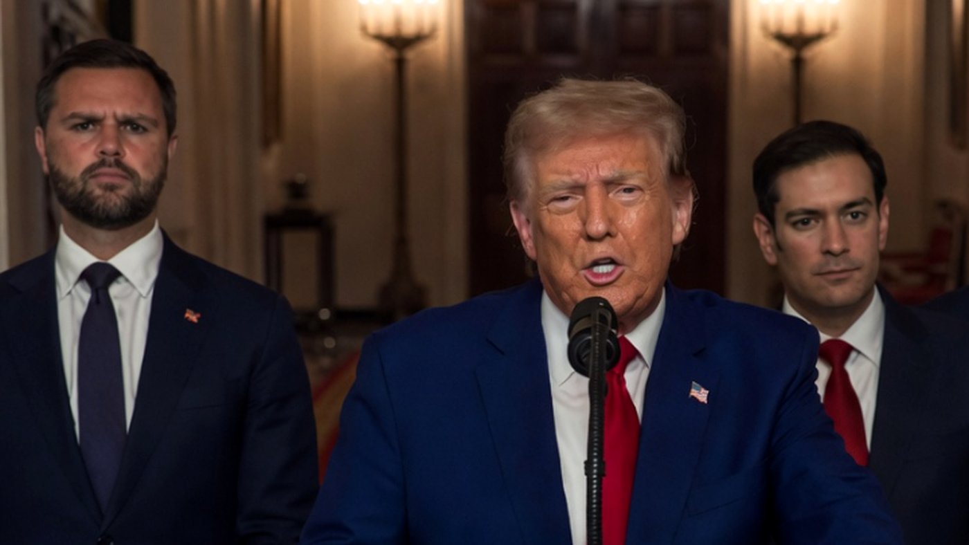 donald Trump speaks at a press conference with two aides