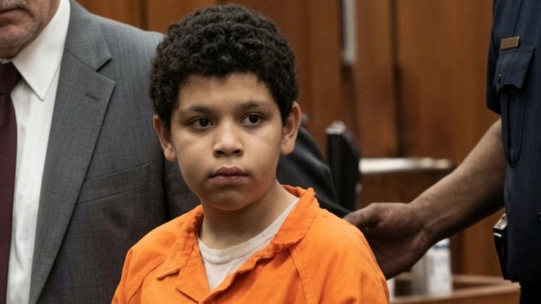 Young boy in an orange jail jumpsuit in court.