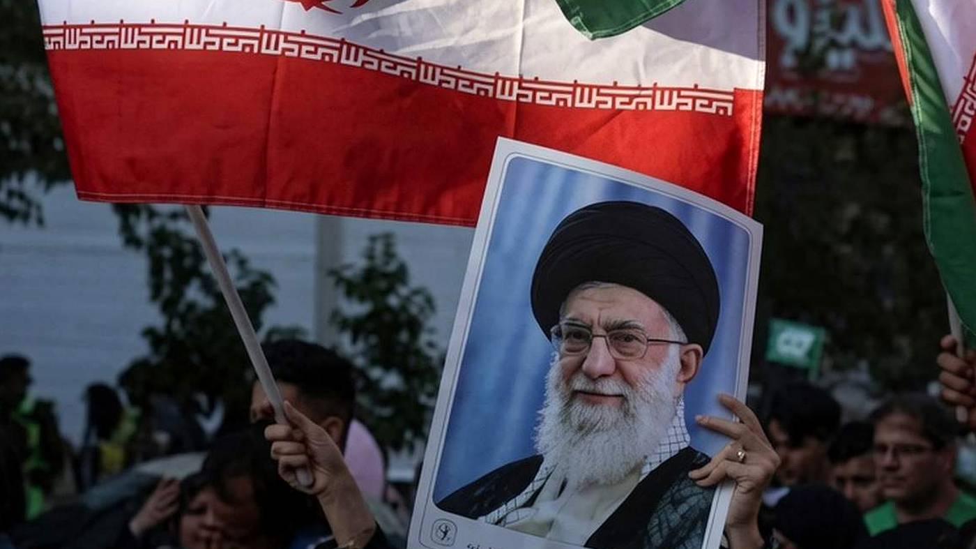 Iranian protesters holding Khamenei portrait and flags