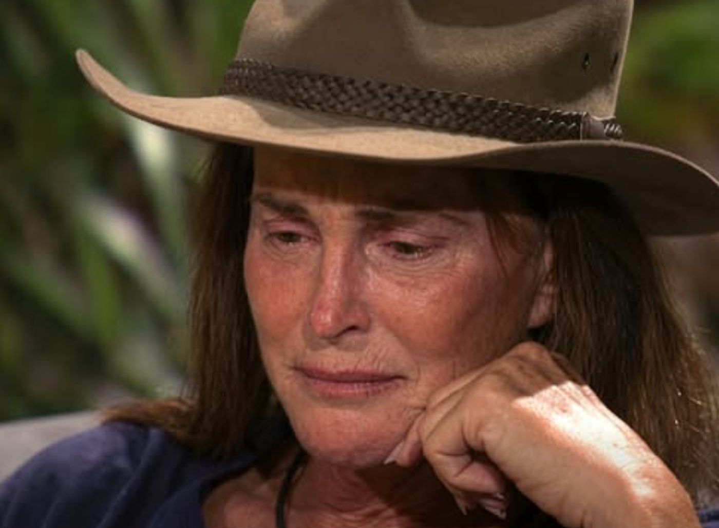 Caitlyn Jenner crying in a wide-brimmed hat.
