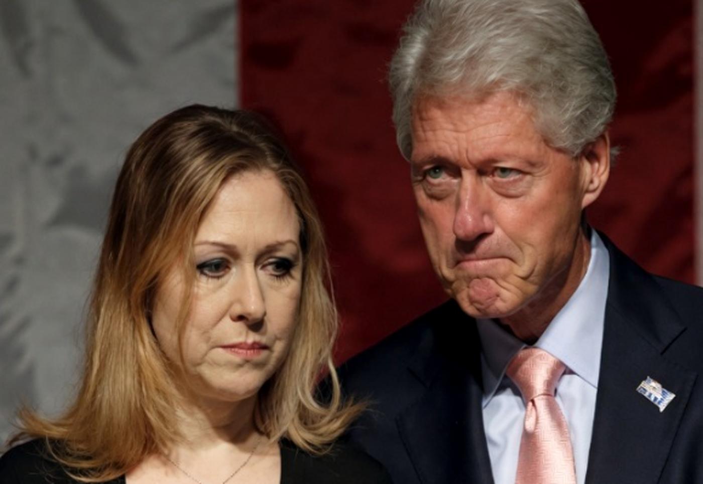 Bill Clinton and Chelsea Clinton look somber.