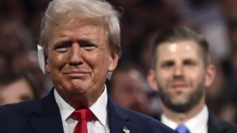 Donald Trump with an ear bandage next to Eric Trump.